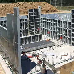 Panneaux de coffrage modulaires en aluminium et acier installés sur un chantier de construction.