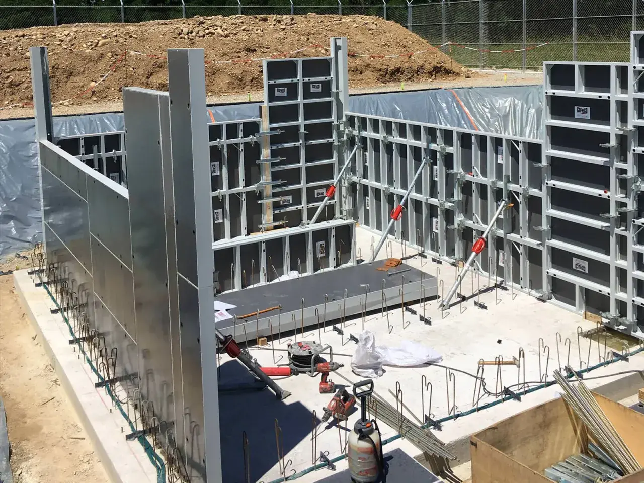 Panneaux de coffrage modulaires en aluminium et acier installés sur un chantier de construction.